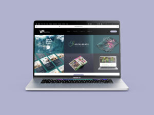 A MacBook Pro laptop displaying a webpage with different graphic design projects. The screen shows various digital and print designs including brochures, website layouts, and marketing materials, all arranged in a visually appealing grid layout. The background is light purple.