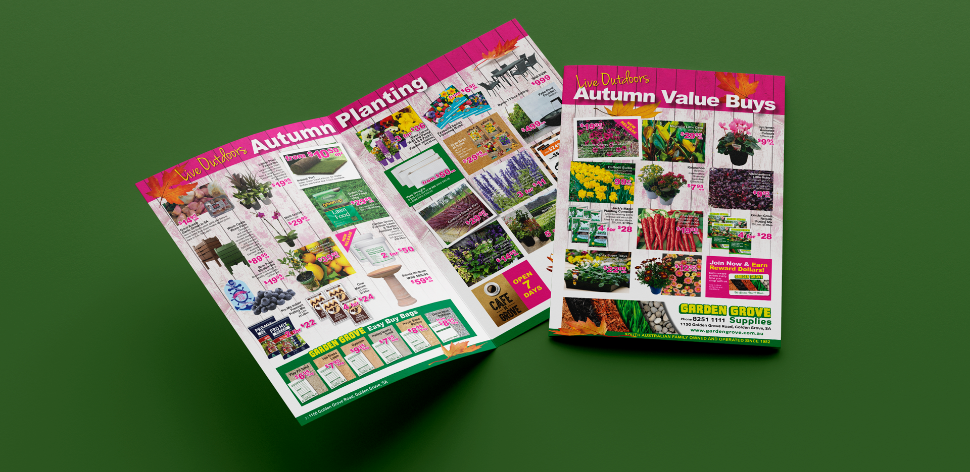 Two colorful garden catalogs titled "New Directions Autumn Planting" and "Autumn Value Buys" are open on a green surface. They feature vibrant images of various plants, gardening supplies, and sale prices, promoting seasonal gardening products from Garden Grove Supplies.