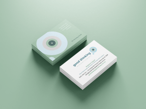 Stacks of business cards for "Good Thinking Psychology" are displayed. The cards feature a minimalist design with a soft green and white color scheme, abstract circular patterns, and the contact details, including a phone number and email address, prominently shown.
